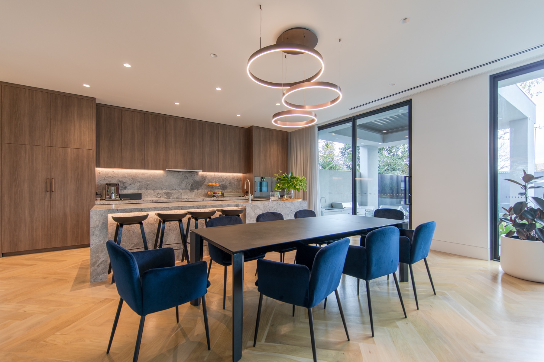 Completed HiCabinet open-plan kitchen beside a ten-seat dining table